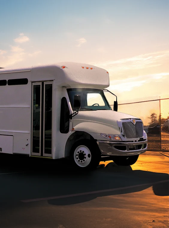 White shuttle bus parked next to a security fence at a prison near Las Vegas